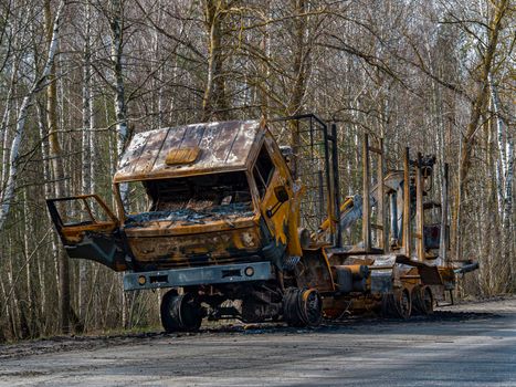 Road traffic accident of a car with fire. Car accident. Road in the forest. Damaged transport. Asphalt pavement. Traffic Laws. Military actions. Motor vehicle. Ukraine.