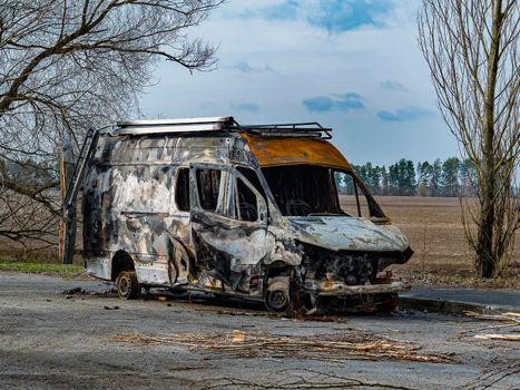 Road traffic accident of a car with fire. Car accident. Road in the forest. Damaged transport. Asphalt pavement. Traffic Laws. Military actions. Motor vehicle. Ukraine.