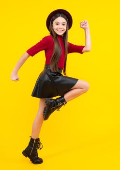 Full size walk on isolated studio wear hat, casual wear, fashion skirt and shoes. Happy teenager portrait. Smiling girl