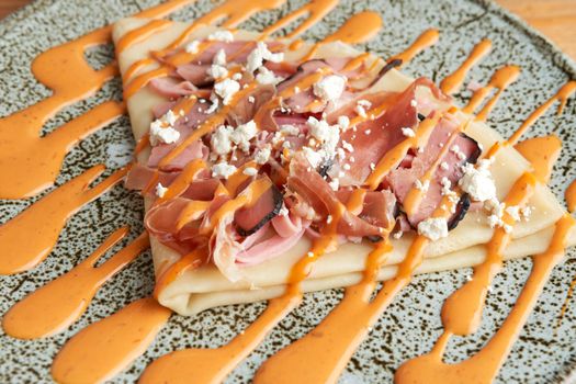 photo of delicious salty crepe with serrano ham, cream cheese and chipotle dressing. salty crepe.
