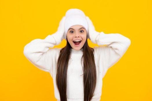 Child with positive expression, joyful and exciting, dressed in casual winter cloth over yellow background with empty space. Excited face. Amazed expression, cheerful and glad