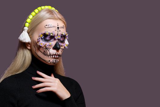 Beautiful Halloween Make-Up Style. Blond Model Wear Sugar Skull Makeup with Red Roses, pale Skin Tones and Waves Hair. Santa Muerte concept