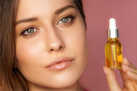 Beauty, makeup and skincare cosmetics model face portrait, woman holding skin care cosmetic essential oil bottle with dropper, luxury facial care product mockup