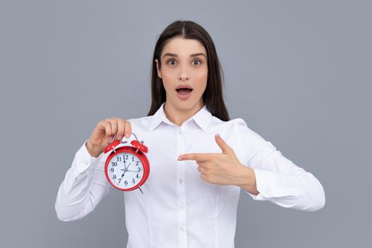 Surprised woman holding alarm watch. Isolated portrait