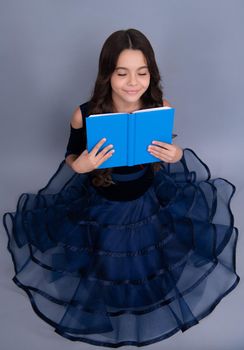 Dreaming schoolgirl in dress hold book and copybook ready to learn. School children dream on isolated grey background