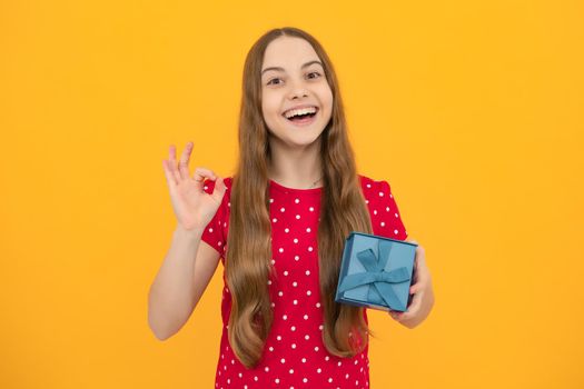 Emotional teenager child hold gift on birthday. Funny kid girl holding gift boxes celebrating happy New Year or Christmas