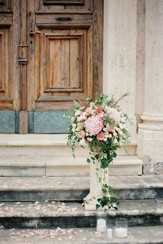Bouquet of flowers stands on a stone pedestal on the steps of the church. High quality photo