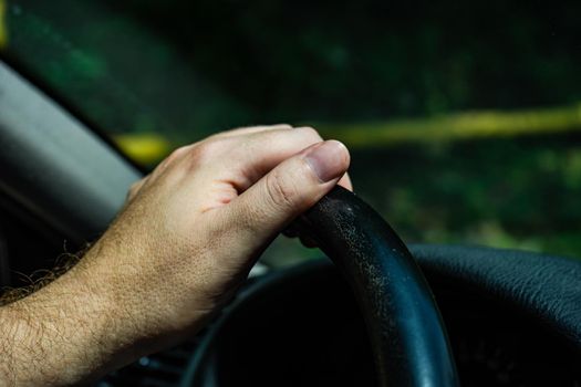 Man hand holding the car wheel in sunny day