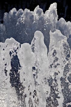 The gush of water of a fountain. Splash of water in the fountain, abstract image.Foam in the sea. The gush of water of a fountain. Splash of water in the fountain, abstract image. High quality photo