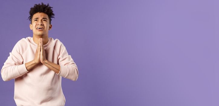 Portrait of young distressed and devestated hispanic guy pleading to god, have difficult situation, praying with hands clasped together over chest, look up supplicating desperate.