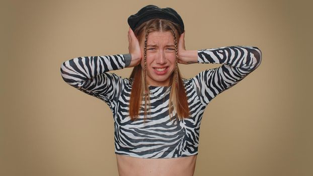 Dont want to hear and listen. Frustrated annoyed irritated pretty young woman covering ears, gesturing no, avoiding advice ignoring unpleasant noise loud voices. Adult stylish girl on beige background