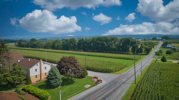 Drone View of Amish Countryside With Barns and Silos, a Patch Work of Corps and Farmlands on Sunny Day.