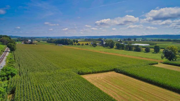 Drone View of Amish Countryside With Barns and Silos and Corn, Patch Work of Color and Corps, on Sunny Day.