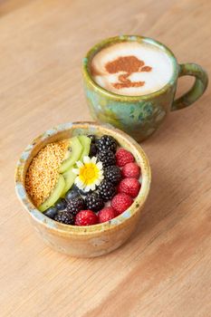 bowl of oatmeal with strawberry and granola on a wooden table. healthy breakfast.