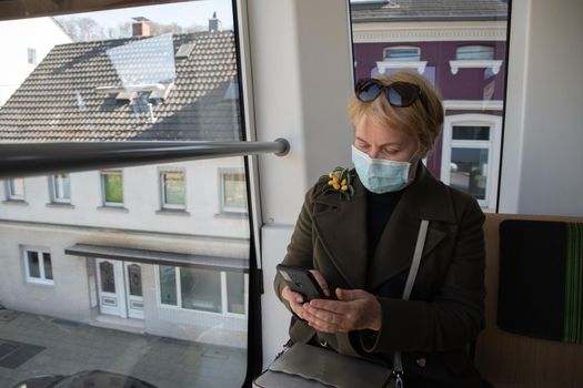 woman looking out the window of Wuppertaler Schwebebahn, Wuppertal suspension railway, unique public transport in Germany, city tram. High quality photo