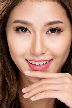 Closeup portrait of ardent young girl with healthy clear skin and soft makeup looking at camera and posing beauty gesture. Cosmetology and beauty concept.