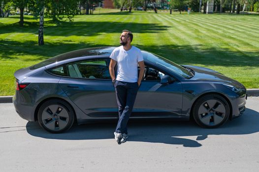 Caucasian man connect charger to electric car