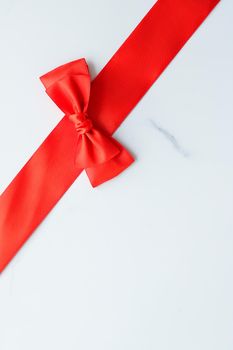 Holiday decor, feminine design and flatlay concept - Red silk ribbon on marble, top view