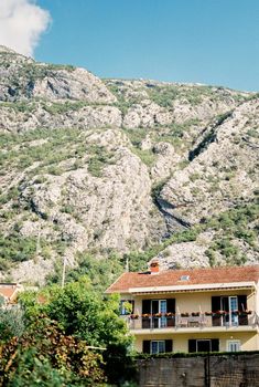 Two-story house among the trees at the foot of the mountains. High quality photo