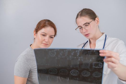 Female doctor explaining mri of internal organs to female patient