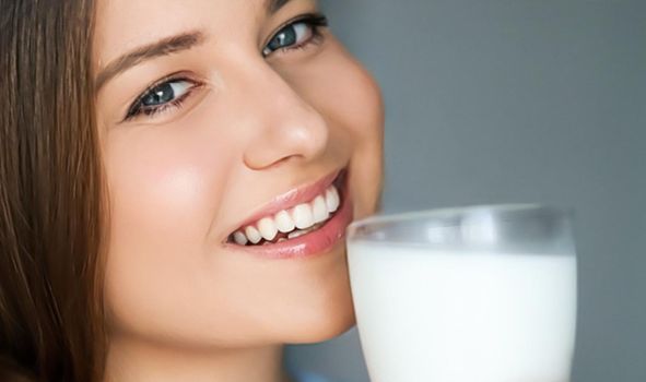 Diet and wellness, young woman with glass of milk or protein shake cocktail, portrait