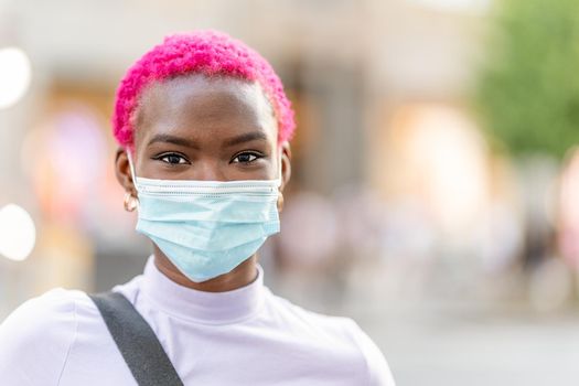 Portrait of a young modern african woman wearing facial protective mask for covid