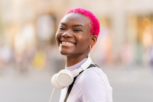 Stylish young afro woman smiling to the camera in the street