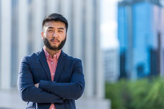 Portrait of an asian man in formal clothes looking at the camera in a business building area