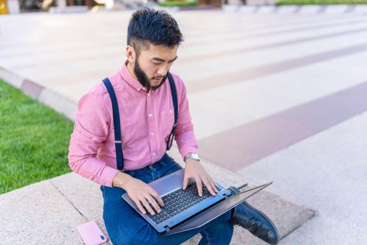 Top view of an asian businessman working with a laptop in the street