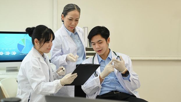 Young research scientist and senior female supervisor analyzing test samples, discussing about new test results in science laboratory.