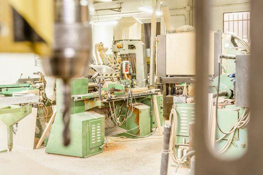 Contemporary industrial machine and other special tools for woodwork placed in joinery behind blurred instrument