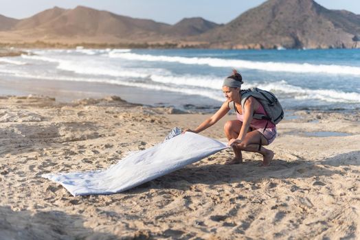 Side view full body of barefoot female traveler near waving sea and rocky hills during summer vacation in Almeria Andalusia Spain