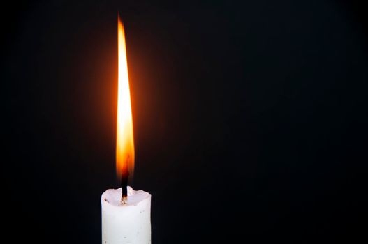 Candle light burning brightly with customizable space for text or ideas. Copy space.
