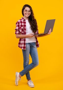 Student school girl with laptop on isolated studio background. Video online webinar, learn on laptop, elearning lesson, pc computer call. Happy teenager, positive and smiling schoolgirl