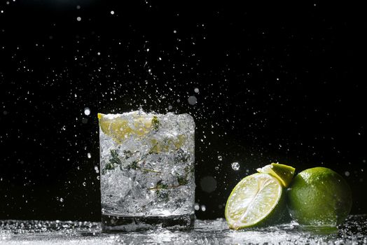 Alcoholic cocktail hard seltzer with splashes on black background.