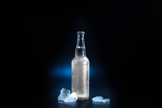 glass bottle with a hard seltzer drink on a black background. Bottle without label.