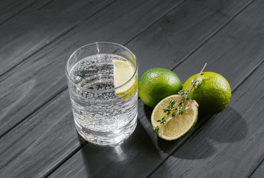 Hard seltzer with lime on a dark wooden background.