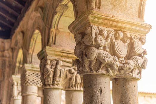 From below of ornament on stone aged columns of Colegiata de Santa juliana Santillana del Mar in Cantabria in Spain in sunny day
