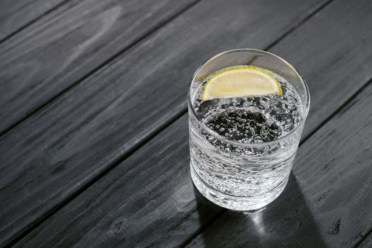 Hard seltzer with lime on a dark wooden background.