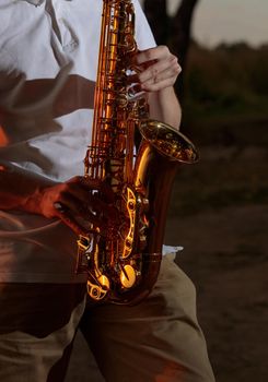 Hands and saxophone close up. The guy plays a wind instrument.