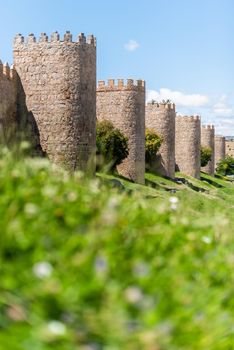 Ground level of ancient Avila Walls with stone towers located in Spain in summer