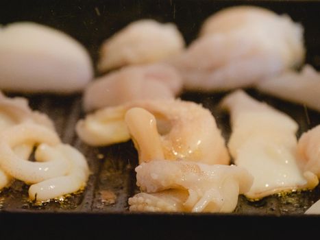 grilling a raw adriatic cuttlefish at home in Numana, Marche, Italy