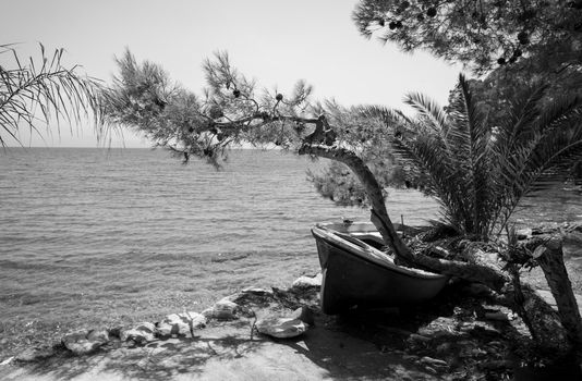 Weathered fishing boat lying on a rocky beach on Petalidi, Messinia, Greece.