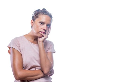 Front view of a green-eyed bored woman looking at camera on a white background with copy space.