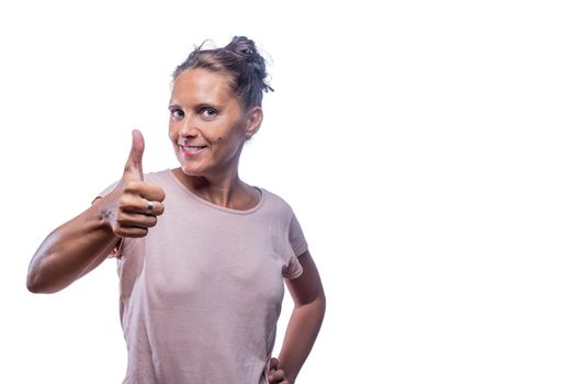 Front view of a positive green-eyed woman showing thumb up on a white background with copy space.