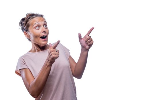 Front view of a surprised green-eyed woman pointing with the index finger of both hands to copy space on a white background