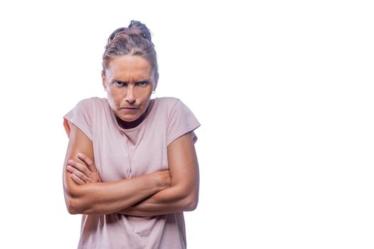 Front view of an abgry green-eyed woman with crossed arms looking at camera on a white background with copy space.