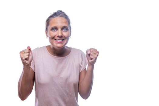 Front view of an excited adult woman with hands up with clenched fists looking at camera on a white background with copy space.