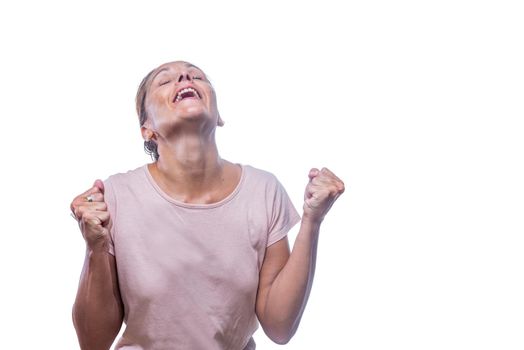 Front view of a grateful or relieved adult woman with clenched fists and head back on a white background with copy space.