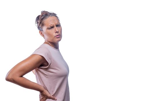 Side view of a woman touching her waist with back pain on a white background with copy space.